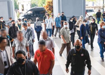 KUmpulan 14 individu yang didakwa atas pemalsuan dokumen Jabatan Pendaftaran Negara (JPN) diiring penguat kuasa JPN tiba di Kompleks Mahkamah Kuala Lumpur semalam. – UTUSAN/SADDAM  YUSOFF