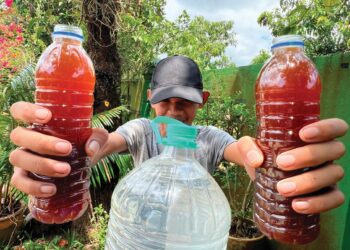 SEORANG pengguna menunjukkan kualiti air yang dilepaskan dari LRA Machang yang tidak boleh digunakan untuk urusan harian di Kampung Pauh Dara, Pasir Puteh, Kelantan. – UTUSAN/TOREK SULONG