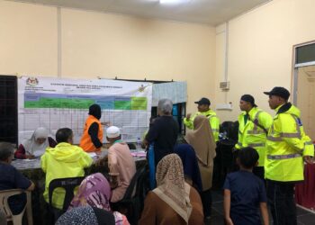 ANGGOTA Polis Jeli turun padang meninjau keadaan terkini mangsa banjir kilat yang berlindung di PPS Kampung Lakota, Jeli, Kelantan malam ini.-IHSAN POLIS