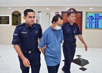 MAT Salleh Jalani (tengah) dituduh melakukan amang seksual fizikal terhadap atlet Sukma dibawa keluar dari Mahkamah Tinggi Kuala Terengganu. - UTUSAN/PUQTRA HAIRRY ROSLI