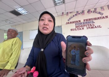 SUHAIDAH Yusof menunjukkan gambar bersama arwah suaminya, Mohd. Taufik Ariff Sariff ketika sambutan Aidilfitri dua minggu lalu.