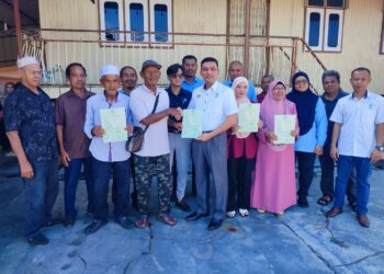 AHMAD Zulkifli Ismail (tengah) menyerahkan geran tanah dan rumah kepada empat keluarga nelayan di Tanjung Dawai, Sungai Petani, Kedah hari ini.