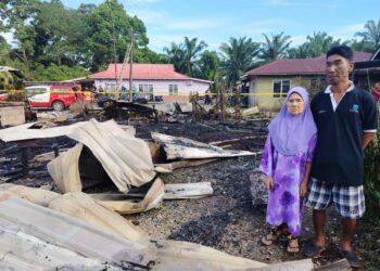 AMINAH Ahmad dan Anuar Mohd. Nor melihat rumah mereka yang musnah terbakar  di Jalan Pusara, Kampung Sungai Chengkeh. Serkat, Pontian, Johor pagi tadi.