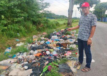 ZAMANI Isa menunjukkan longgokan sampah yang terletak hanya 100 meteri dari SRA JAIM Pernu di Taman Seri Telok Emas, Melaka, hari ini.UTUSAN/AMRAN ALI.