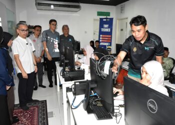 FAHMI Fadzil (kiri) melawat Pusat Sebaran Maklumat Nasional (NADI) Air Kuning sempena Hari bersama Komuniti NADI Air Kuning di Tapah hari ini. - UTUSAN/ZULFACHRI ZULKIFLI