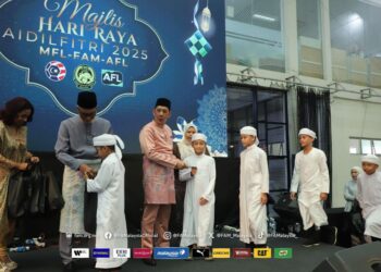 Mohd Joehari Mohd Ayub (kanan) menyampaikan sumbangan kepada pelajar sempena sambutan Rumah Terbuka Aidilfitri FAM, MFL dan AFL di Kelana Jaya, semalam. - IHSAN FAM