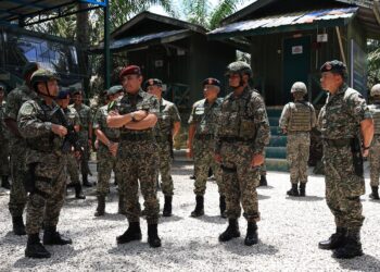 MUHAMMAD Hafizuddeain Jantan (tiga kanan) beramah mesra dengan anggota TDM selepas mengadakan lawatan dan sambutan Hari Raya Aidilfitri di Pos Tok O, Rantau Panjang, Kelantan hari ini-UTUSAN/KAMARUL BISMI KAMARUZAMAN.