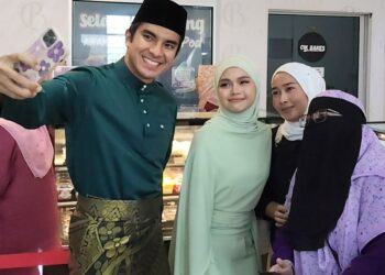 SYED Saddiq Syed Abdul Rahman (kiri) bersama Bella Astilah berswafoto dengan peminat semasa perasmian kedai kek dan colak di Kok Lanas, Kelantan hari ini-UTUSAN/YATIMIN ABDULLAH.