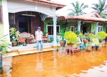 DARUS Buang melihat air banjir yang masih bergenang di halaman rumahnya walaupun sudah tiga minggu berlaku.