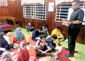 MOHD. Nasrullah Che Halim  bersama kanak-kanak yang menyertai bimbingan mengingati maksud al-Quran di Kampung Banggol Pak Esah, Pasir Puteh, Kelantan. – UTUSAN/TOREK SULONG