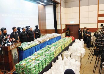 Mat Zani @ Mohd. Salahuddin Che Ali menunjukkan pelbagai jenis dadah yang berjaya dirampas di Bukit Aman, semalam. – UTUSAN/FAUZI BAHARUDIN