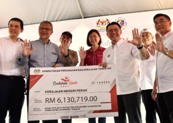 NGA Kor Ming (dua dari kanan) menyerahkan cek bagi pelaksanaan 33 projek pembangunan dan infrastruktur kepada penduduk Tapah. - UTUSAN