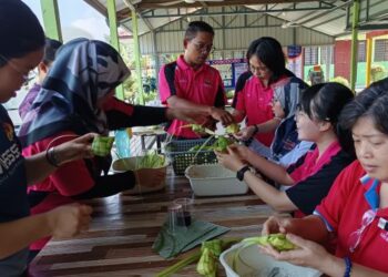 GURU dan ibu bapa berbangsa Cina di Sekolah Jenis Kebangsaan Cina (SJKC) Chi Sin, Batu Kikir tekun menganyam ketupat sempena Hari Raya Aidilfitri di sekolah itu semalam. – UTUSAN/NOR AINNA HAMZAH