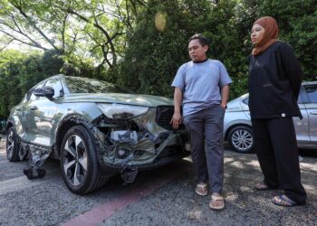 PENDUDUK, Azam Mokhtar bersama isterinya, Nazira Abd. Aziz
melihat kenderaan mereka yang rosak akibat kesan letupan saluran
paip gas yang berlaku di Jalan Putra Harmoni, Putra Heights, Selangor.