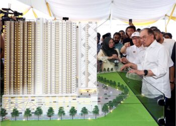 ANWAR Ibrahim melihat model rumah mampu milik pada Majlis Pecah Tanah Projek Pembangunan Rumah Belia Madani dan Rumah Mampu Milik di Mukim Batu, PPR Batu Muda, Kuala Lumpur, semalam. – UTUSAN/SHIDDIEQIIN ZON