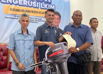  MUHAMMAD Faiz Fadzil  (tengah) menyampaikan replika enjin bot kepada nelayan di Penempatan Semula Nelayan, Tok Bali, Pasir Puteh, Kelantan. - UTUSAN/TOREK SULONG