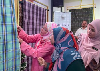 TUNKU Azizah Aminah Maimunah Iskandariah menunjukkan keunikan dan kelainan karya kain Tenun Pahang Diraja sempena sidang akhbar Piala Tunku Azizah di Kompleks Kraf, Kuala Lumpur. - UTUSAN/NURUL NATASHA SURIN