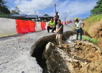 MOHD. AZMAWI FIKRI Abdul Ghani (kanan) meninjau rekahan dan
jalan berlubang yang dikesan di Kilometer 35, Jalan Gua Musang-Jeli,
Kelantan. – UTUSAN/AIMUNI TUAN LAH