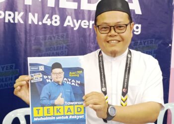 Calon PN, ABD. Muhaimin Malek menunjukkan manifesto yang ditawarkan sempena PRK Ayer Kuning pada sidang akhbar di Tapah, semalam. - UTUSAN
