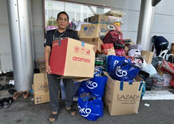 RAJA Hilmy bersama lambakan barang yang melebihi keperluan berbanding jumlah mangsa di PPS Masjid Putra Heights. - UTUSAN/AIMAN ALI