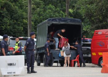 PENDUDUK Taman Putra Harmoni, Subang Jaya, Selangor menaiki trak untuk pulang ke rumah mereka bagi membuat pemeriksaan sambil diiringi pihak berkuasa. UTUSAN/FARIZ RUSADIO