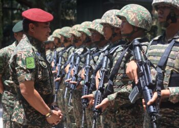 MUHAMMAD Hafizuddeain Jantan (kiri) beramah mesra dengan anggota Tentera Darat Malaysia semasa melakukan pemeriksaan barisan di Pos Tok O, Rantau Panjang, Kelantan hari ini-UTUSAN/KAMARUL BISMI KAMARUZAMAN.