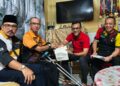 ZUL Amirul Sidi Abdullah menerima kunjungan daripada Mustapha (dua dari kanan baju merah) yang memberi sumbangan dan meninjau keadaan atlet para renang di kediamannya.-UTUSAN/NOR SHAFAWATI YUP.