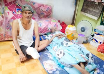 AHMAD Ishak (kiri) yang kudung kaki menjaga kebajikan bapanya yang sakit tua di Felda Kota Gelanggi Dua, Jerantut, Pahang. - UTUSAN/HARIS FADILAH AHMAD