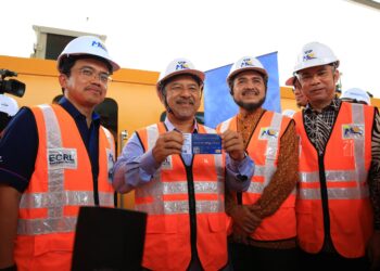 DARWIS Abdul Razak  (kiri) melihat Mohd. Nassuruddin Daud menunjukkan tiket Laluan Rel Pantai Timur (ECRL) semasa Majlis Lawatan Kerja di Stesen ECRL Pasir Puteh, Kelantan. - UTUSAN/KAMARUL BISMI KAMARUZAMAN