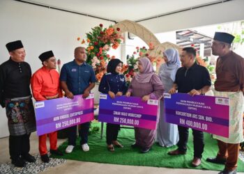 RUPIAH Wang (empat dari kanan) menyampaikan mock cheque kemudahan pembiayaan perniagaan kepada usahawan pada Program Hari Bertemu Pelanggan Kementerian Kemajuan Desa dan Wilayah di Kampung Baru Serada, Kuala Terengganu. -UTUSAN/PUQTRA HAIRRY