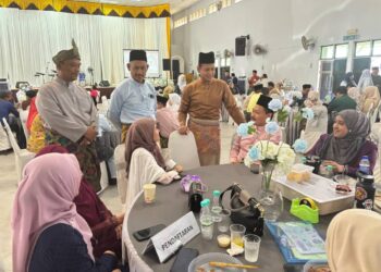 MOHD. Mufsi Lat (berdiri, kanan) menyantuni tetamu pada majlis rumah terbuka Aidilfitri Kementerian Perdagangan Dalam Negeri dan Kos Sara Hidup Terengganu di Kuala Nerus, Terengganu. - UTUSAN/KAMALIZA KAMARUDDIN