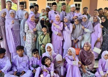 SHAZLI Salim (tiga atas kiri) dan keluarga isterinya memakai baju raya berwarna Lilac di Kampung Gong, Terengganu sempena Hari Raya Aidilfitri, baru-baru ini.