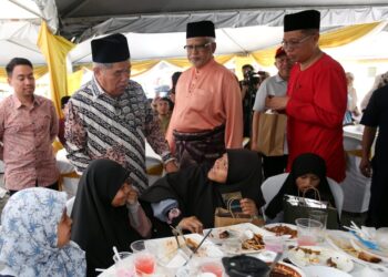 MOHAMAD Sabu (kiri) menyantuni anak yatim pada Majlis Ramah Mesra Bersama Anggota Lembaga Pertubuhan Peladang (LPP) Negeri Perak di pejabat Pertubuhan Peladang Kawasan (PPK) Tapah hari ini. - UTUSAN