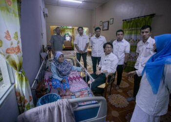 MUHAMMAD Kamil Abdul Munim menyantuni penduduk di Kampung Pasir Batu Masjid di Temoh, Tapah pada Program Ziarah Kasih Madani DUN Ayer Kuning semalam. - UTUSAN