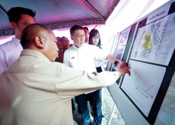 NGA Kor Ming melihat pelan kerja-kerja naik taraf Jalan Medan Ipoh hari ini. - UTUSAN