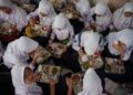 PELAJAR di Sekolah Menengah Negeri 12 di Cimahi, Jawa Barat, menikmati makan tengah hari pada hari pertama program makanan percuma pada 6 Januari lalu.- AFP