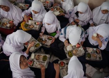 PELAJAR di Sekolah Menengah Negeri 12 di Cimahi, Jawa Barat, menikmati makan tengah hari pada hari pertama program makanan percuma pada 6 Januari lalu.- AFP