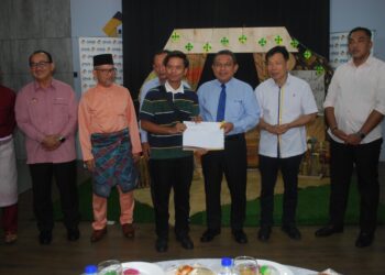 SETIAUSAHA Kerajaan Negeri, Datuk Azhar Arshad menyampaikan surat inden kerja RMR kepada salah seorang kontraktor sambil diperhatikan Mohd. Azmi Mohd. Lila (dua dari kanan) di Pejabat SPNB Melaka, Taman Lagenda, Melaka. - UTUSAN/AMRAN MULUP