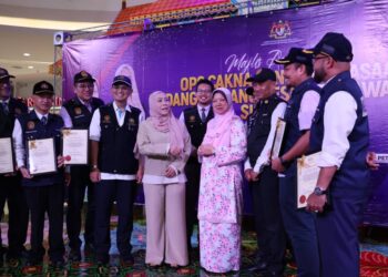NORHAYATI Rusli (depan, kiri) beramah mesra dengan pegawai penguat kuasa kesihatan selepas melancarkan Op Cakna di Kuala Terengganu, semalam. - UTUSAN/KAMALIZA KAMARUDDIN