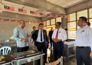 KHAIRUDIN Abu Hanipah (kiri) meninjau sekolah terjejas akibat ribut di daerah Perak Tengah baru-baru ini. - UTUSAN