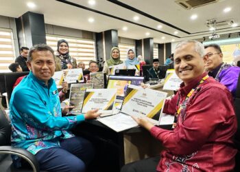SAFUAN Raba’ai (kiri) menunjukkan analisis keputusan SPM 2024 di Pejabat Jabatan Pendidikan Negeri (JPN) Perak di Ipoh hari ini. - UTUSAN/LIYANA RAMLI