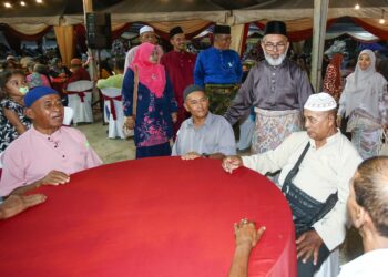 SYED Abu Hussin Hafiz Syed Abdul Fasal bersama pengunjung majlis sambutan Hari Raya Aidilfitri anjuran beliau di Bukit Gantang semalam. - UTUSAN/MUHAMAD NAZREEN SYAH MUSTHAFA