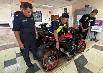 MOHD. Zamri Samion (tengah) memeriksa motosikal milik mekanik yang merempuh sekatan jalan raya (SJR) di Jalan Sultan Mohamad, Kuala Terengganu - UTUSAN/PUQTRA HAIRRY ROSLI