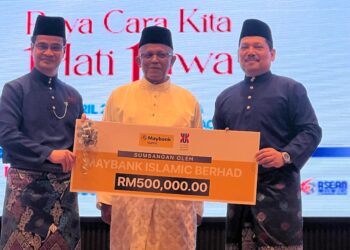 ARHAM Abdullah (kiri) menerima sumbangan kewangan daripada rakan strategik sambil disaksikan Hassan Basri (tengah) di Universiti Malaysia Kelantan (UMK) Kampus Bachok, Kelantan. - UTUSAN/TOREK SULONG