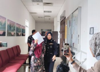 NUR Fadilah Zainal (kiri) meninggalkan Kompleks Mahkamah Syariah Melaka selepas didenda RM5,000 kerana percubaan melakukan kegiatan tidak bermoral. UTUSAN/MUHAMMAD SHAHIZAM TAZALI