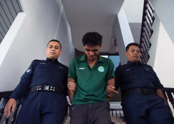 MUHAMMAD Syafiq Mohamad Izhar diiringi anggota polis selepas didakwa mencuri rantai emas dan tabung syiling di Mahkamah Majistret, Ayer Keroh, Melaka. - UTUSAN/ARIF HAMIZAN MISKON