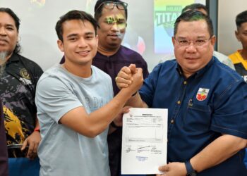 AKRAMUDDIN Abdul Aziz menyerahkan kontrak kepada pemain Melaka Titans di Balai Raya Baruh Alai, Telok Mas, Melaka. - UTUSAN/AMRAN MULUP