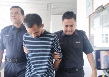 MALKAN Maha diiringi anggota polis ketika dihadapkan ke Mahkamah Sesyen, Ayer Keroh, Melaka atas pertuduhan meliwat seorang remaja lelaki. - UTUSAN/MUHAMMAD SHAHIZAM TAZALI