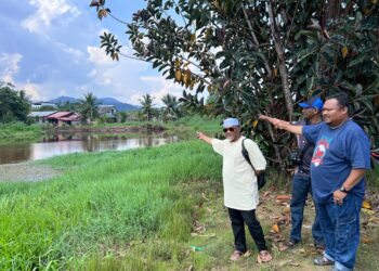 HAIRUL FAUZI Mokli (dua dari kiri) dan Mohamad Yusri Yusuf (kiri) menunjukkan kedudukan Sungai Simpang Kiri yang terlalu hampir dengan rumah penduduk di Kampung Melayu Sungai Lontok di Parit Sulong, Batu Pahat, Johor.