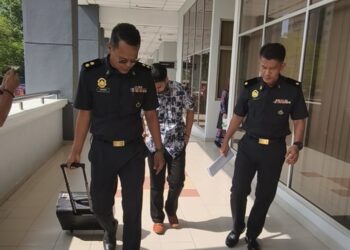 AHMAD Nizamuddin Setapa (tengah) didakwa di Mahkamah Sesyen Seremban hari inii atas lima pertuduhan memiliki dan memindahkan barang kawalan minyak masak melebihi had dibenarkan serta tidak menyelenggara buku stok, tahun lalu. - UTUSAN/NOR SHAFAWATI YUP